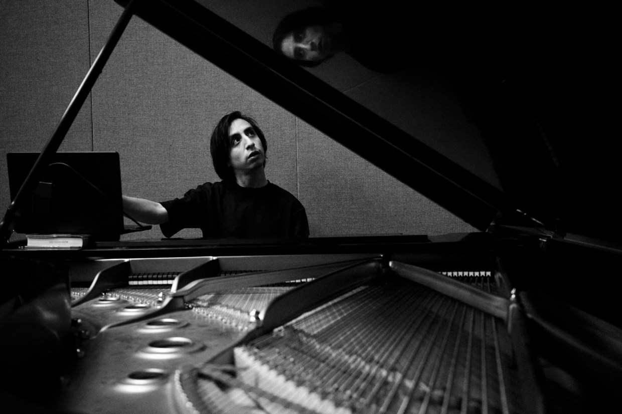 Photo of a man sitting by a piano