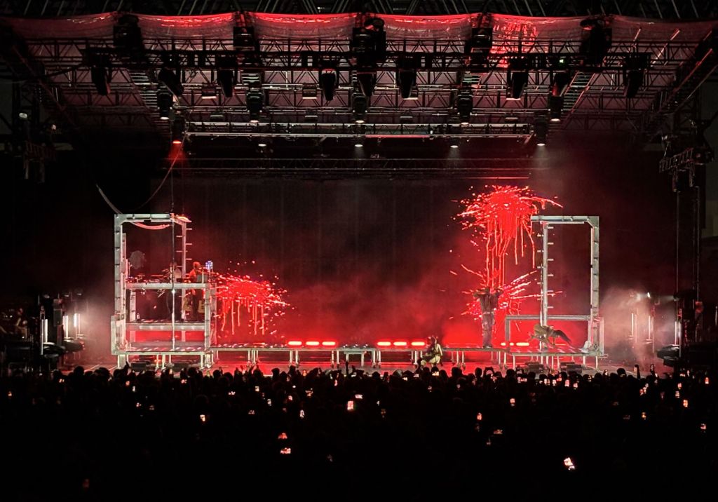 Photo of a big stage with a screen showing red splashes .