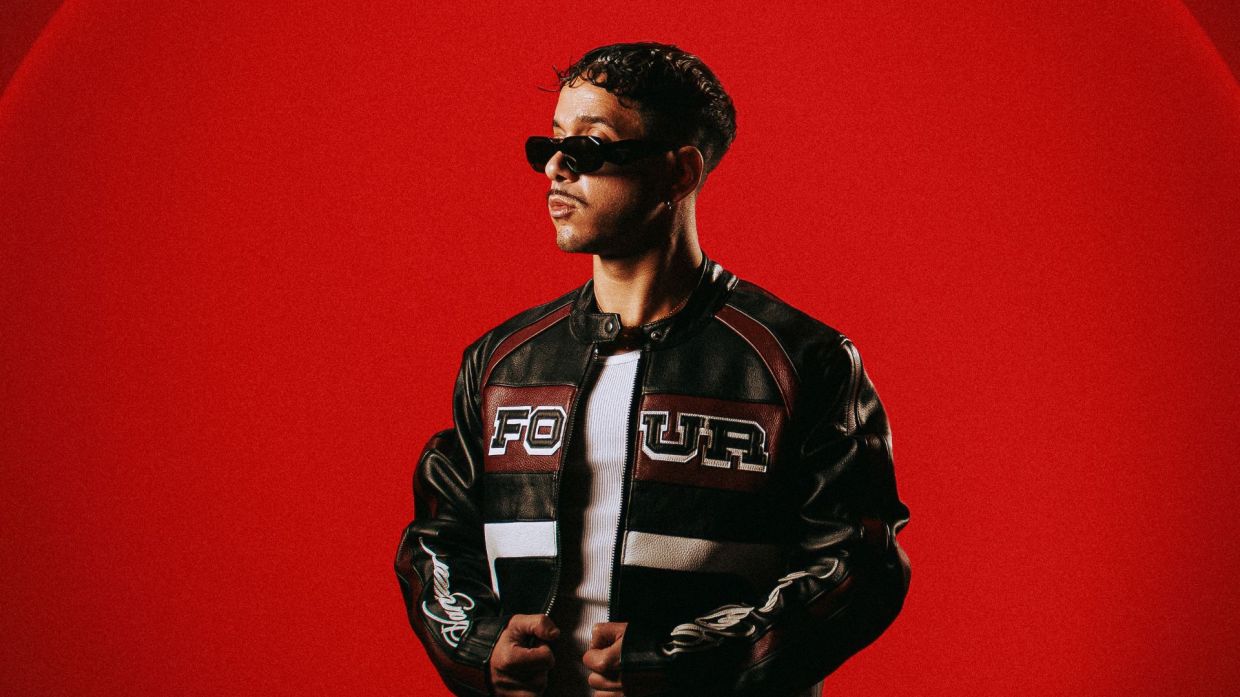 Photo of Kybba in front of a red background.