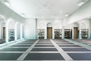 rendering of a yoga studio with rows of mats on the floor and domed mirrors on the left