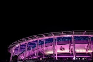 photo of a stadium lit up in purple lighting at nighttime