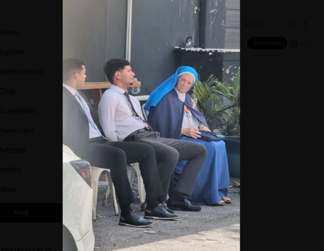 A photo of a nun sitting next to a two men wearing suits,