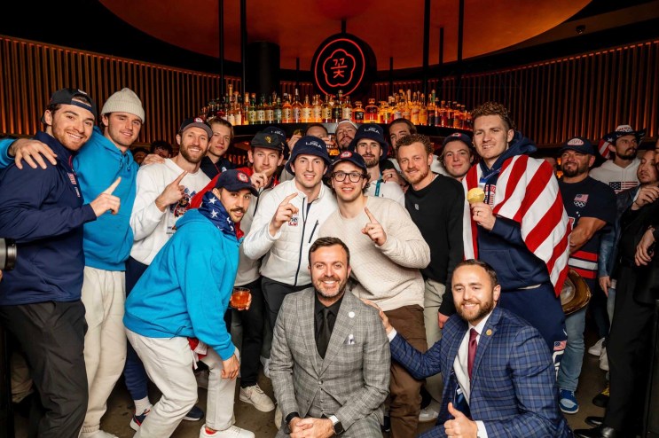 photo of the U.S. Men’s Hockey Team huddling for a photo inside a club