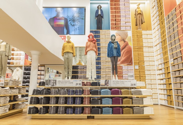 A photo of mannequins wearing winter clothing inside a Uniqlo clothing store.