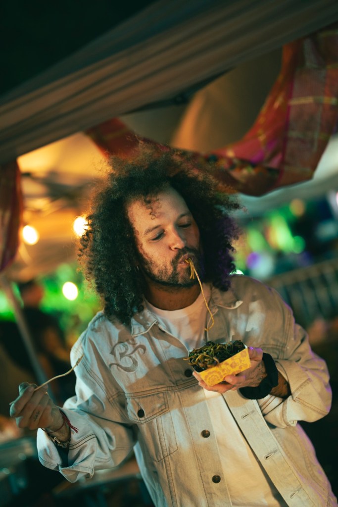 Photo of a man eating noodles at a festival in Miami.