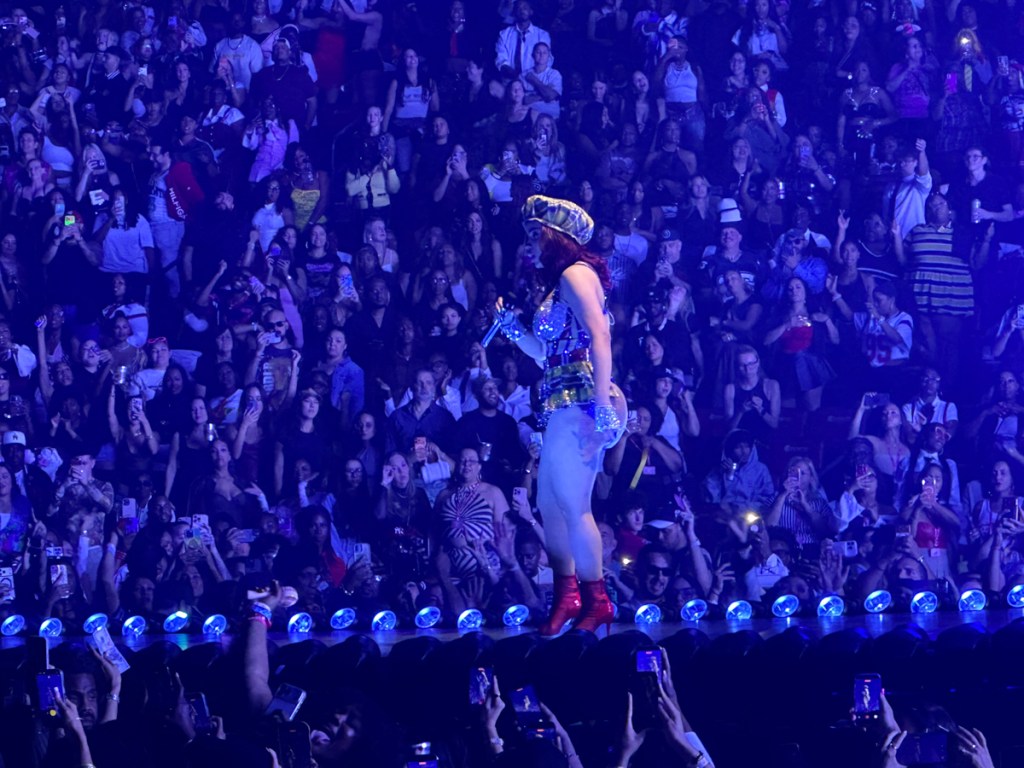 Photo of Cardi B on stage surrounded by fans