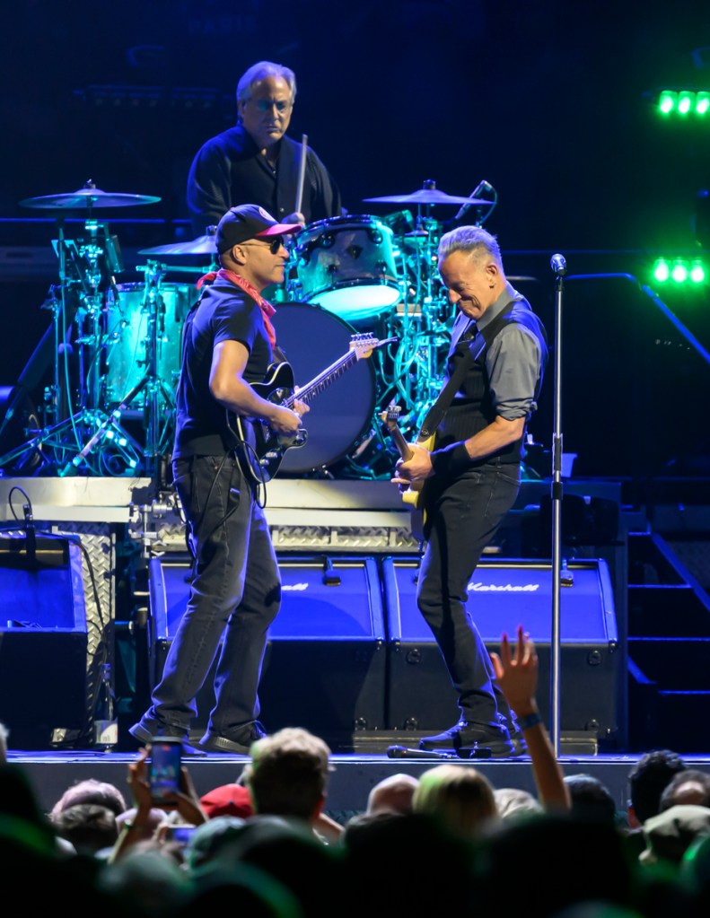 Photo of Bruce Springsteen and Tom Morello performing at the Amerant Bank Arena