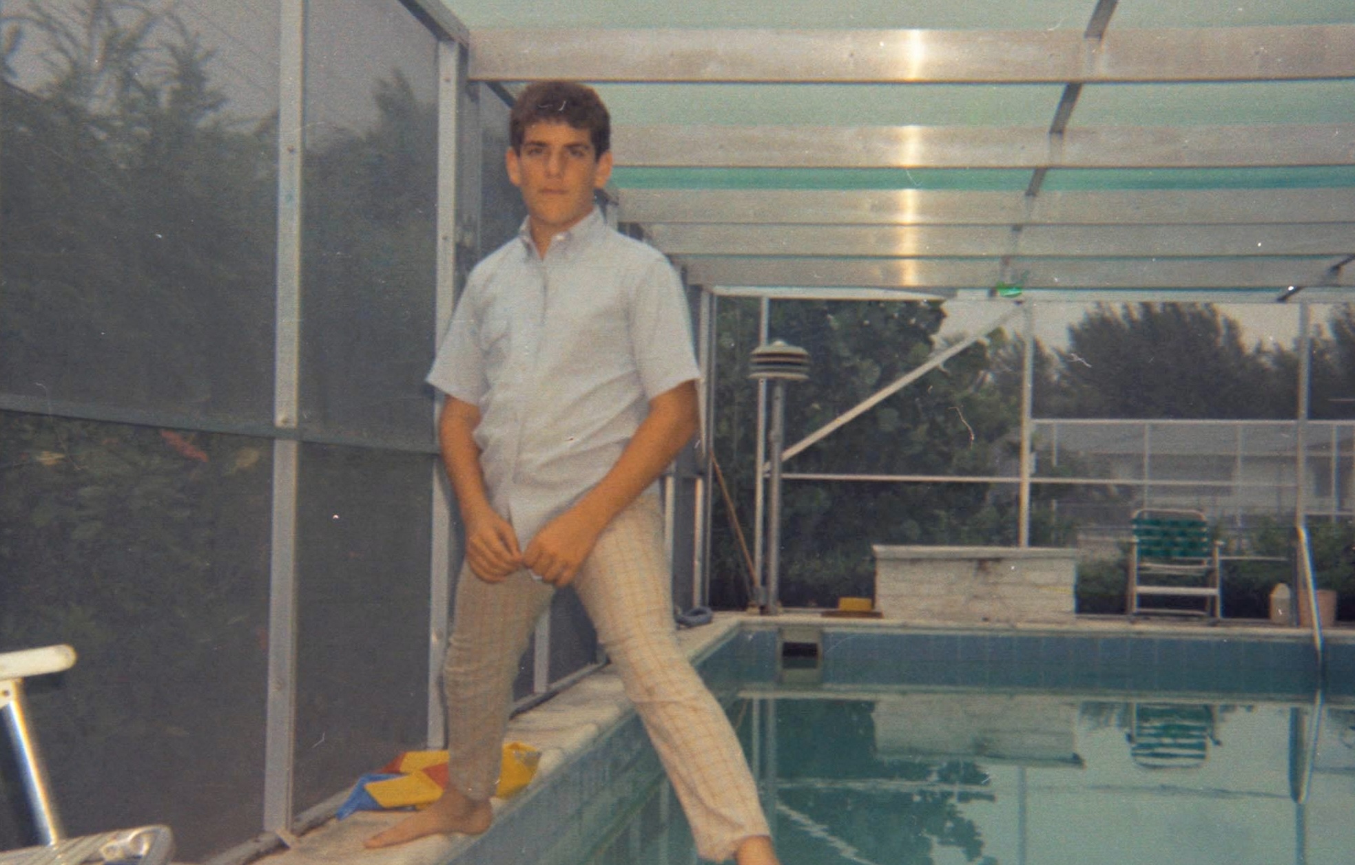 grainy photo of a young boy standing over a pool in the '70s