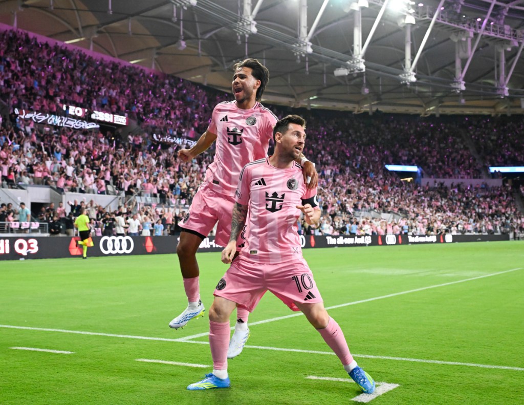 photo of Telasco Segovia leaping next to Lionel Messi