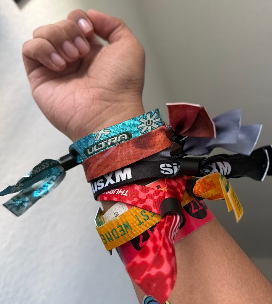 Photo of the arm of a person wearing many wristbands.