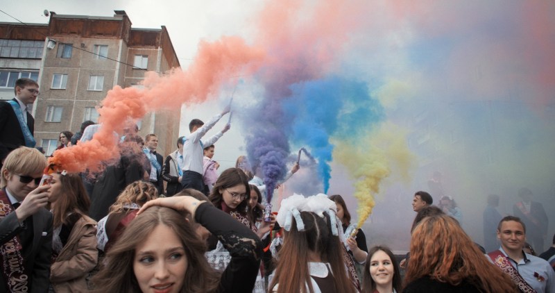 film still from the documentary Mr Nobody Against Putin showing colored smoke flares above a crowd