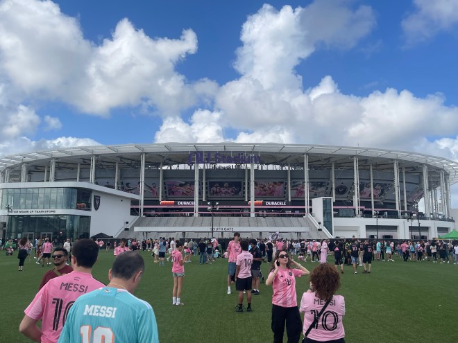 soccer fans walk in front of Miami's new stadium
