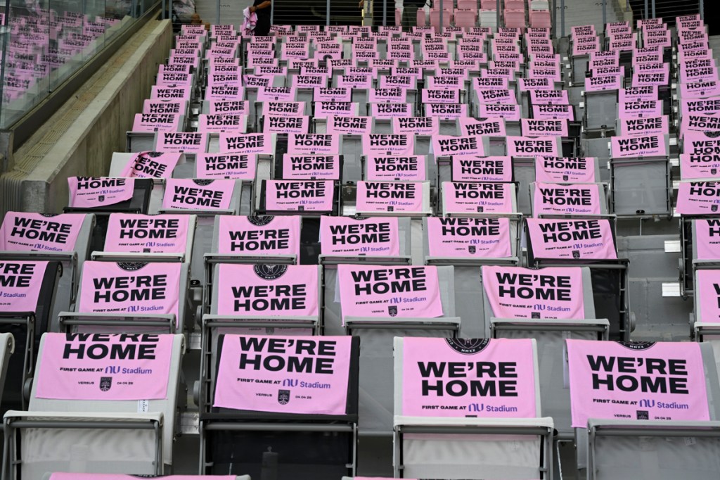 photo of signs reading, "We're Home" on the stands at Nu Stadium