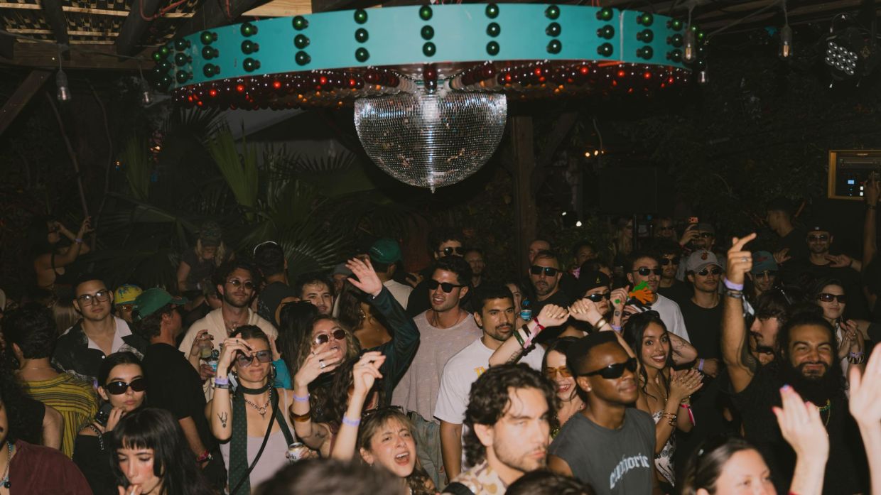 Photo of a crowd dancing under a disco ball in Miami.