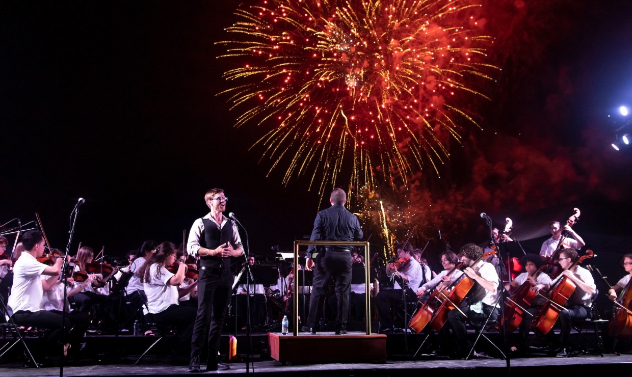 Photo of an orchestra performing in Miami Beach in front of Fire works