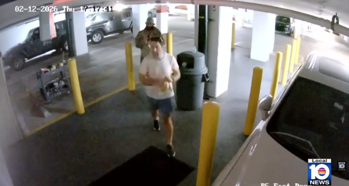 A screenshot from surveillance video showing two men walking in a parking garage.