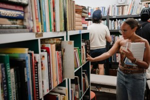 photo of a woman digging through the racks inside a library