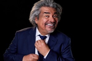 photo of comedian George Lopez smiling and adjusting his tie