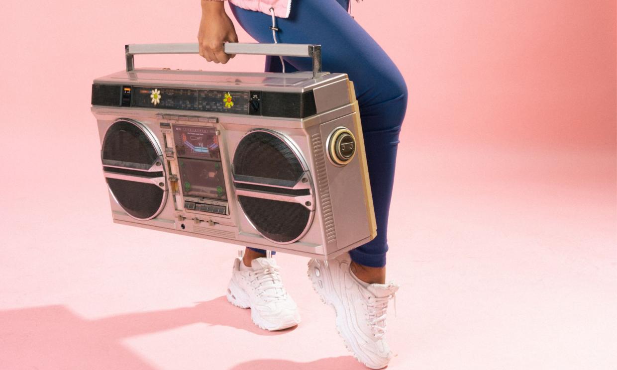 Photo of a woman holding a retro music player.