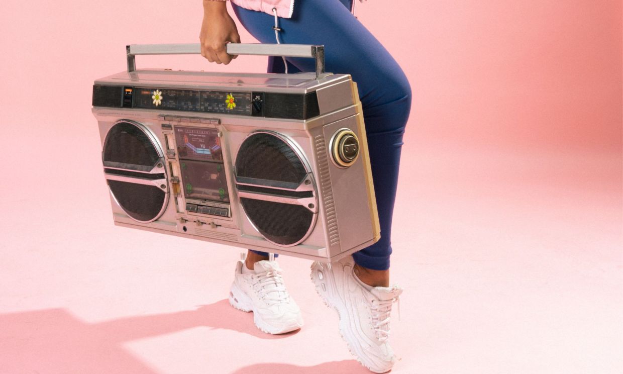 Photo of a woman holding a retro music player.
