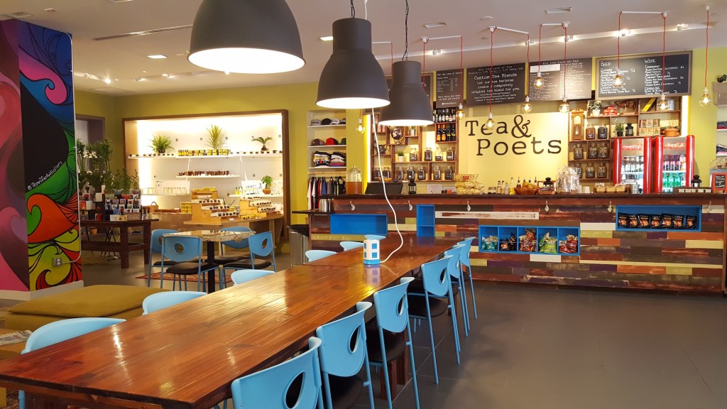 Photo of an empty coffee shop. The sign behind the bar reads, "Tea & Poets"