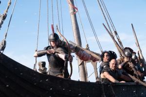 film still depicting Matt Damon as Odysseus slinging arrows from a ship under siege in Christopher Nolan's "The Odyssey"