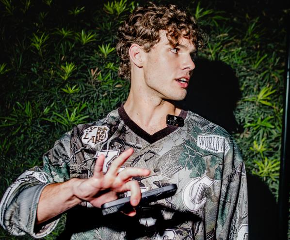 A young man puts his hand in front of a camera