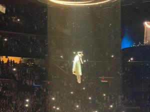 photo of singer Ariana Grande being lifted to the roof of an arena on harnesses