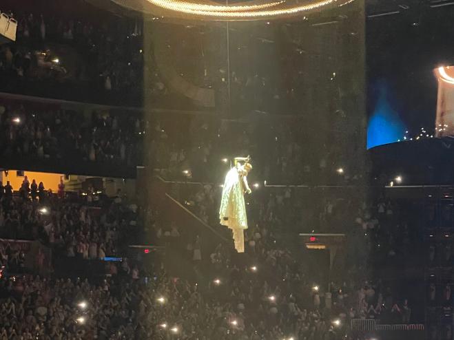 photo of singer Ariana Grande being lifted to the roof of an arena on harnesses