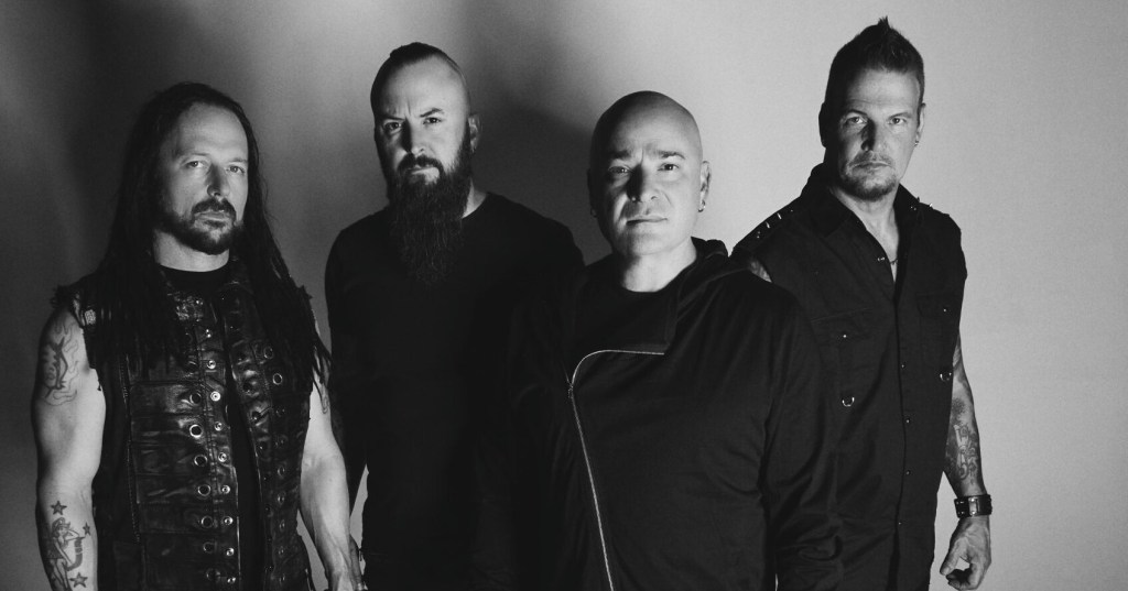 black-and-white photo of the band Disturbed posing in black outfits