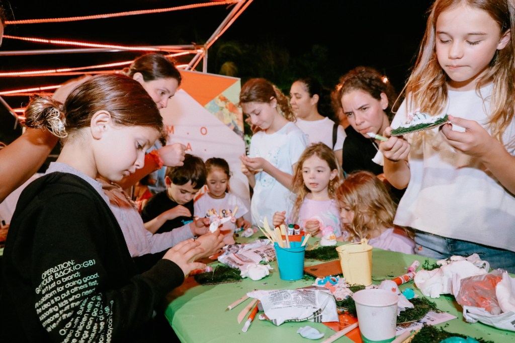 photo of children surrounding an art station table inside a museum