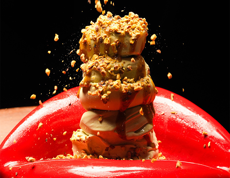 a modern dessert on a bright red lip-shaped dish