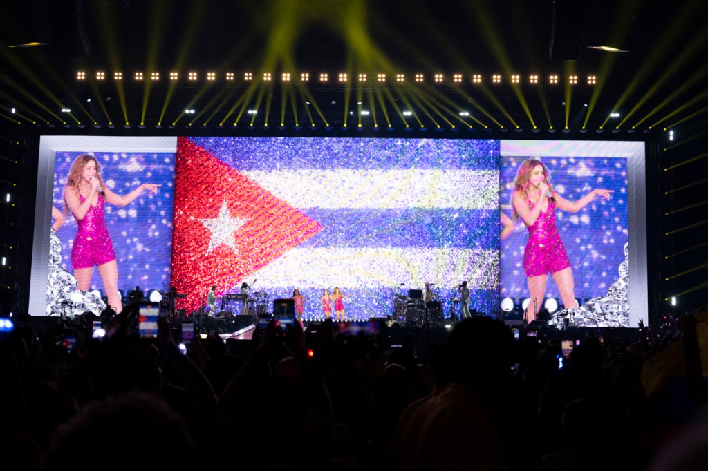 Photo of Shakira on stage in Miami by an LED screen showcasing the Puerto Rican flag