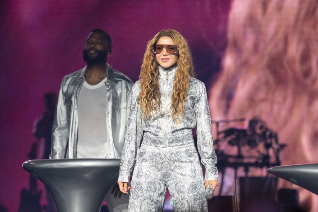 Photo of Shakira on stage in Miami wearing sunglasses and a silver outfit
