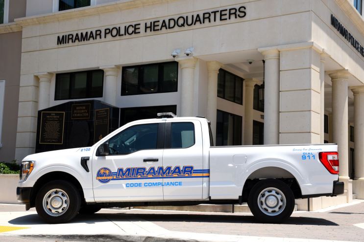 a white police truck sits parked in front of a building