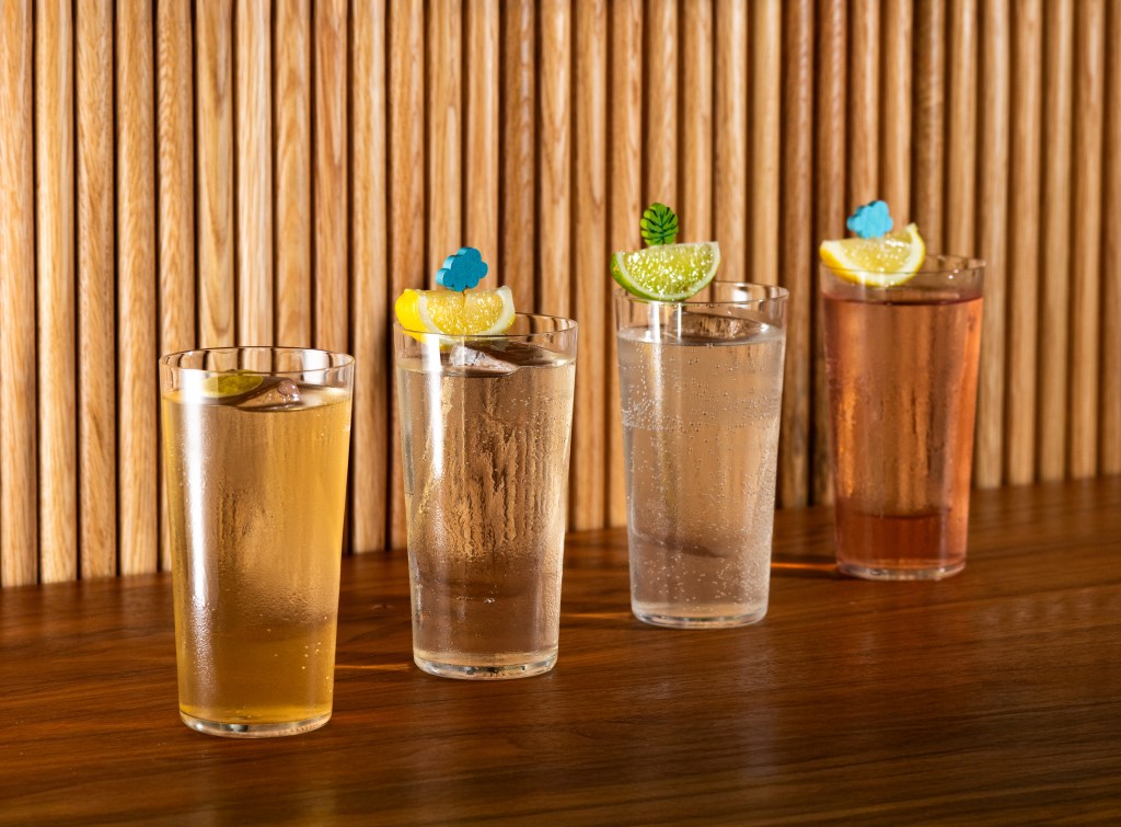four cocktails in front of wooden plank background