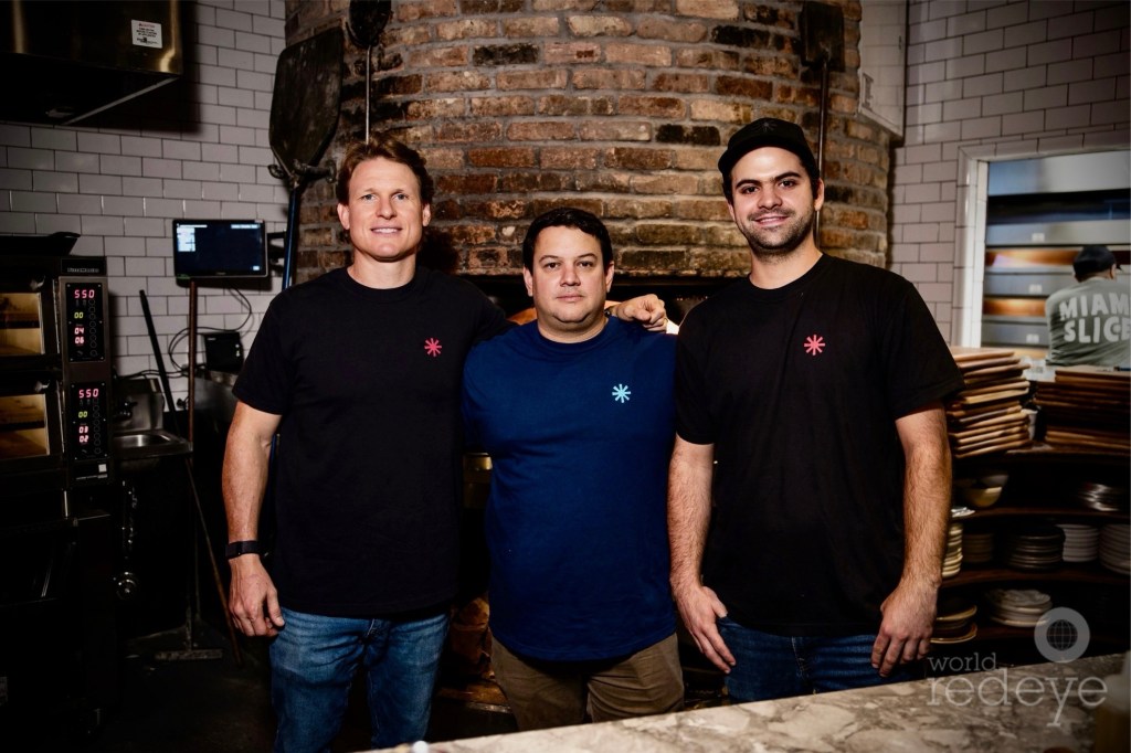 photo of three men inside a pizza shop