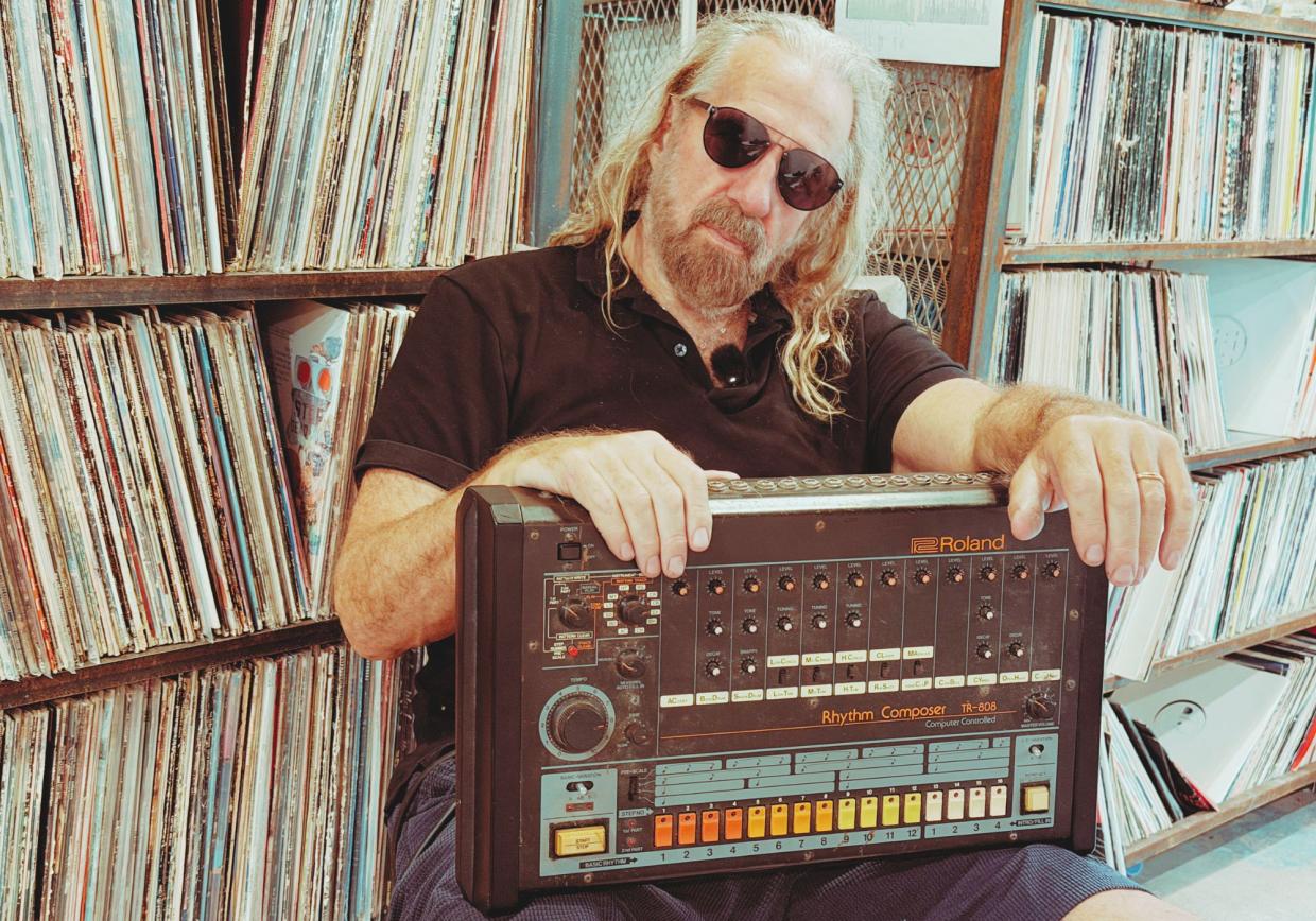 Photo of a man with long hair holding a Rolland 808