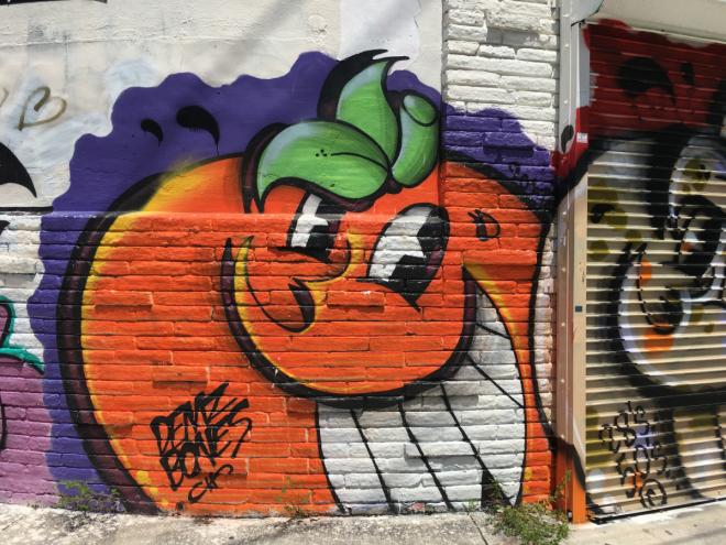 A photo of a mural featuring a smiling orange.
