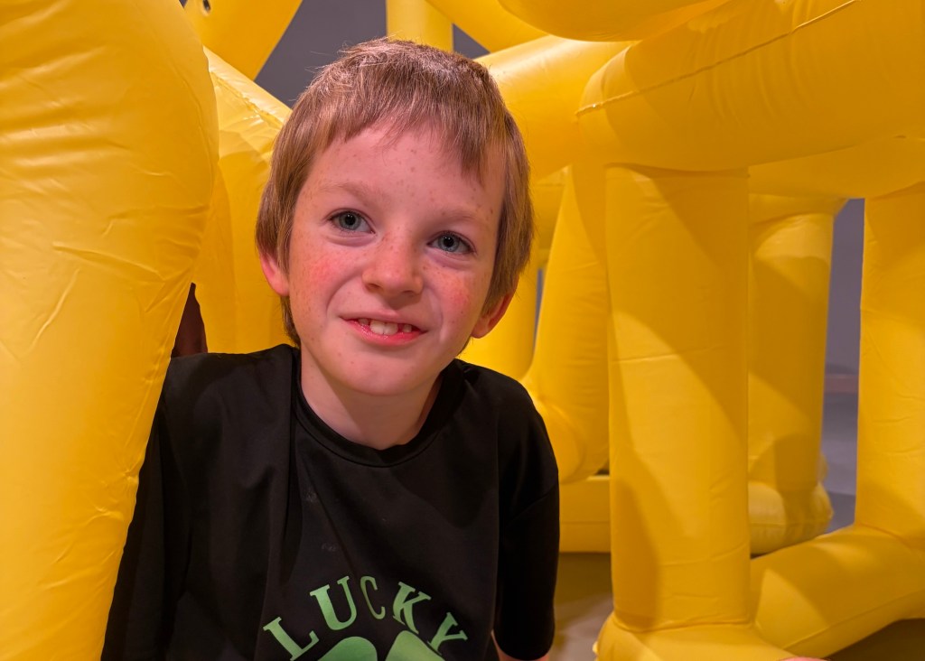 photo of a young child smiling among inflatables inside an experiential museum
