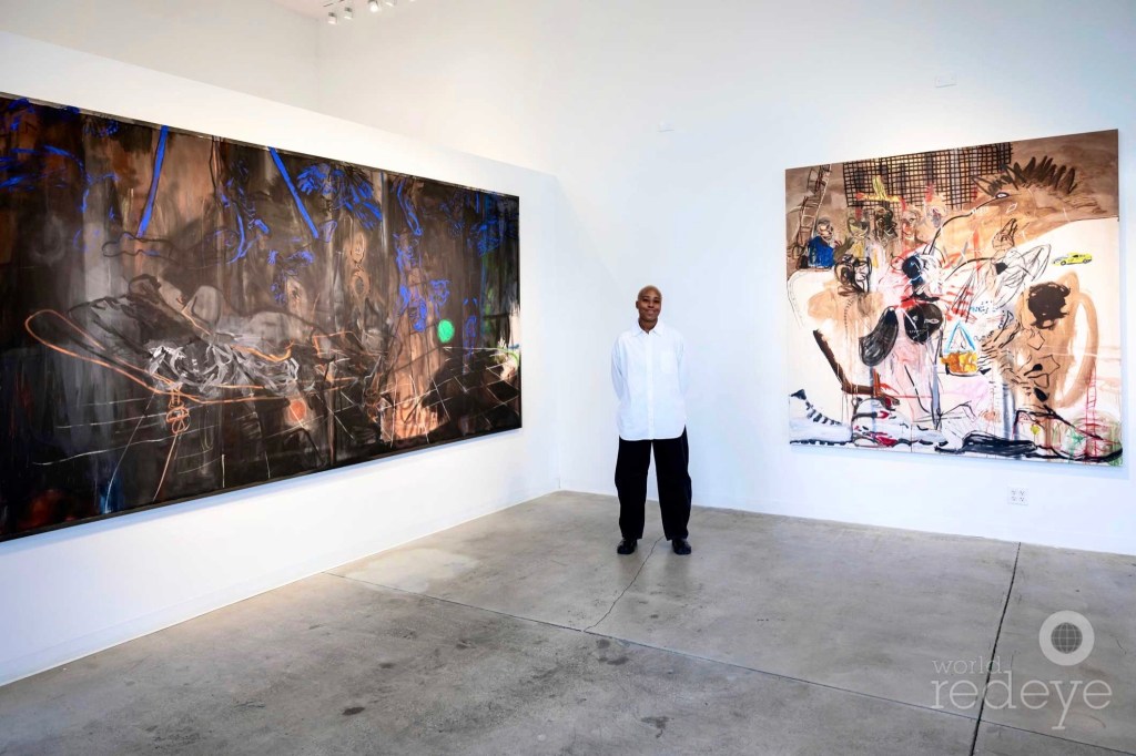 photo of artist Chantae Elaine Wright posing in front of two pieces inside a gallery