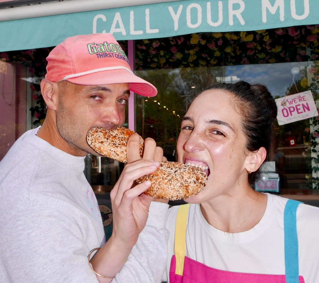 two people eating bagels