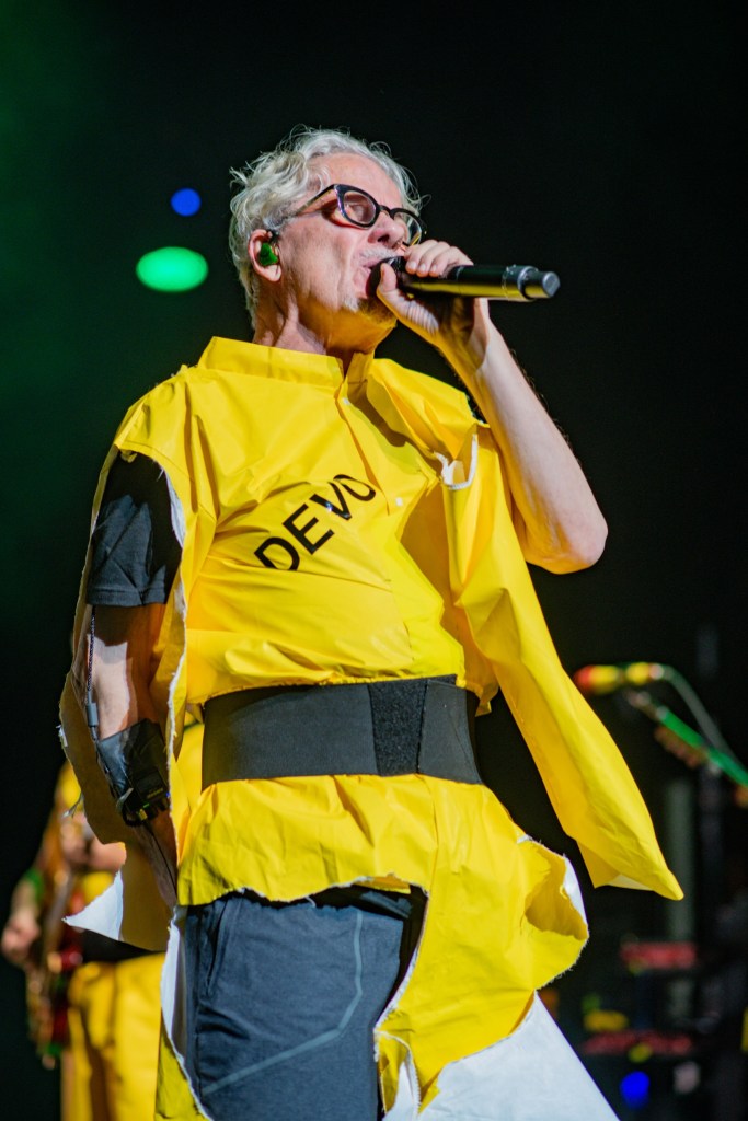 Photo of a member of Devo wearing a yellow jumpsuit