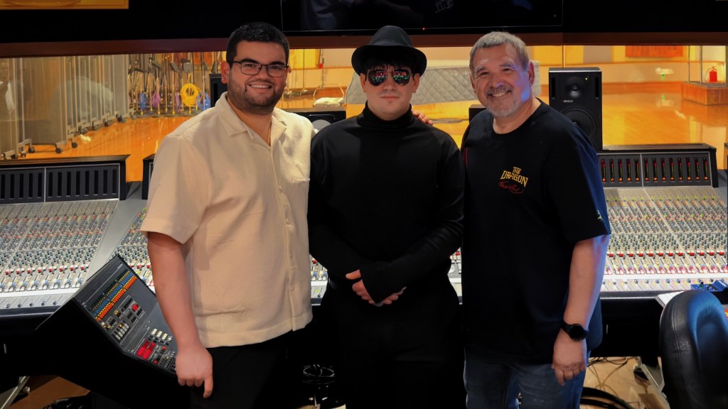 Photo of three men at a recording studio in Miami