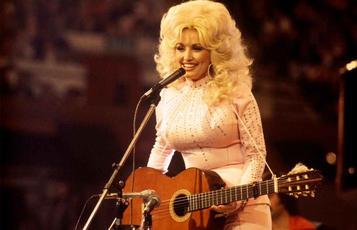 Photo of singer, songwriter and actress Dolly Parton, performs with a guitar, 1976. (Photo by David Redfern/Redferns)