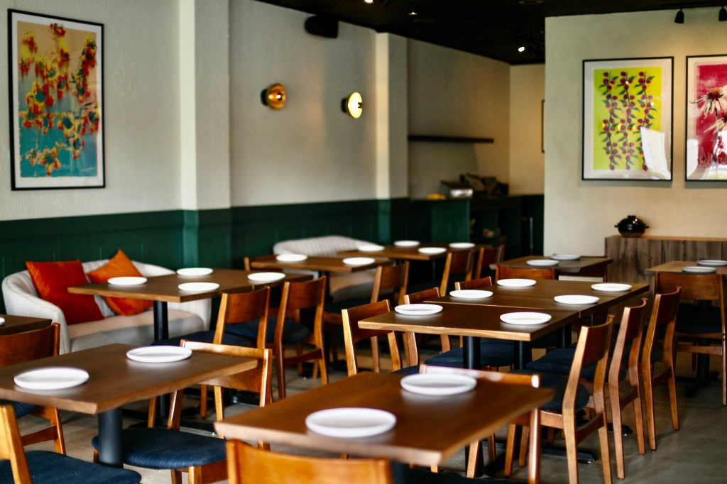 a dining room with plates on tables and wall art on the walls