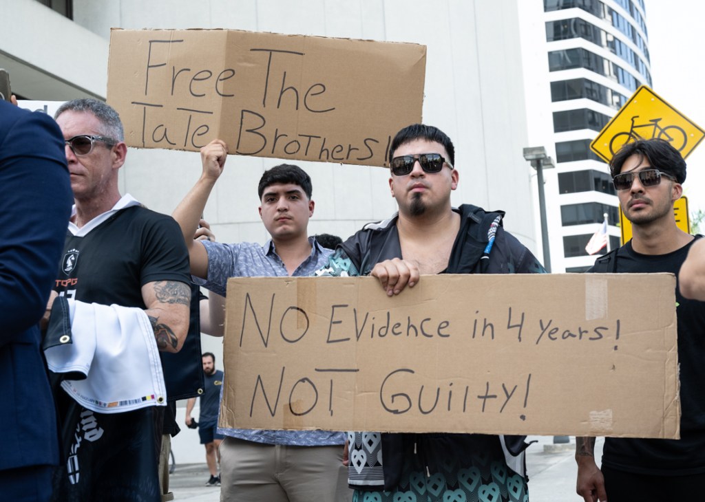 men hold cardboard signs in downtown Miami
