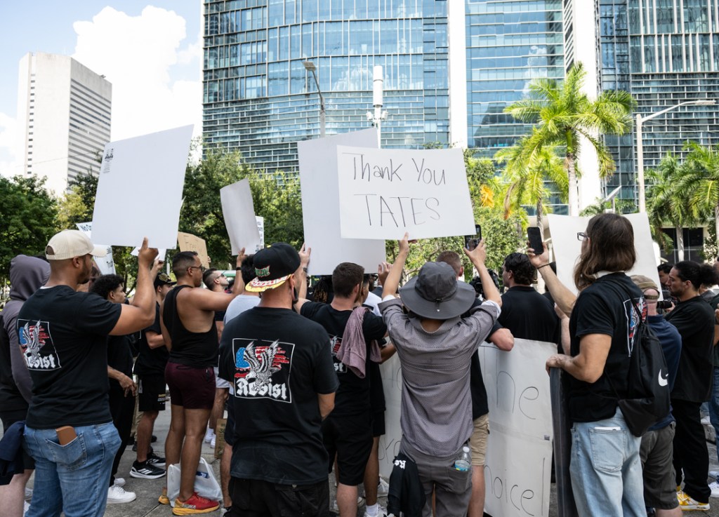 protestors hold signs in downtown Miami