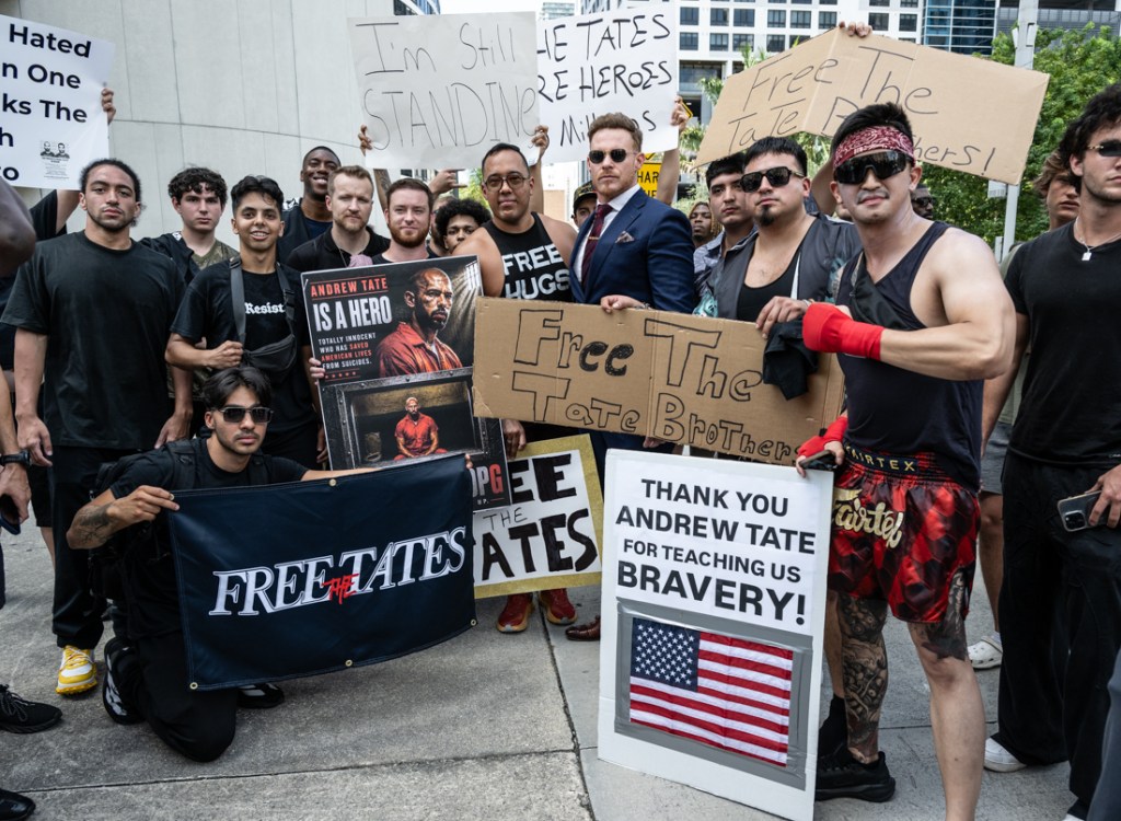 men gather in downtown Miami with signs demanding the release of Andrew Tate