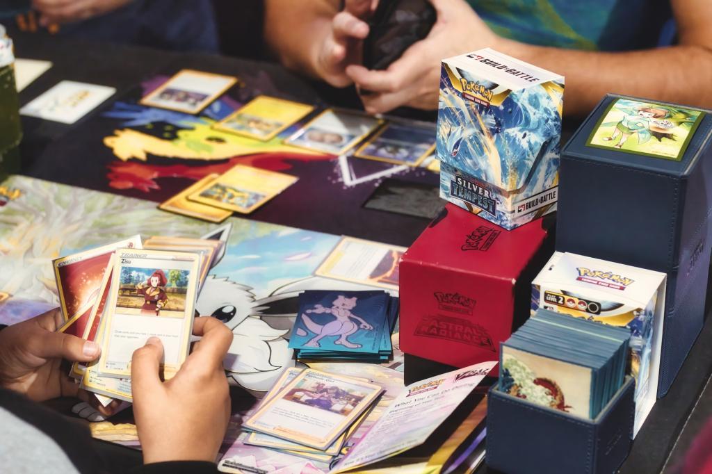 photo of two people playing with Pokemon trading cards on a table